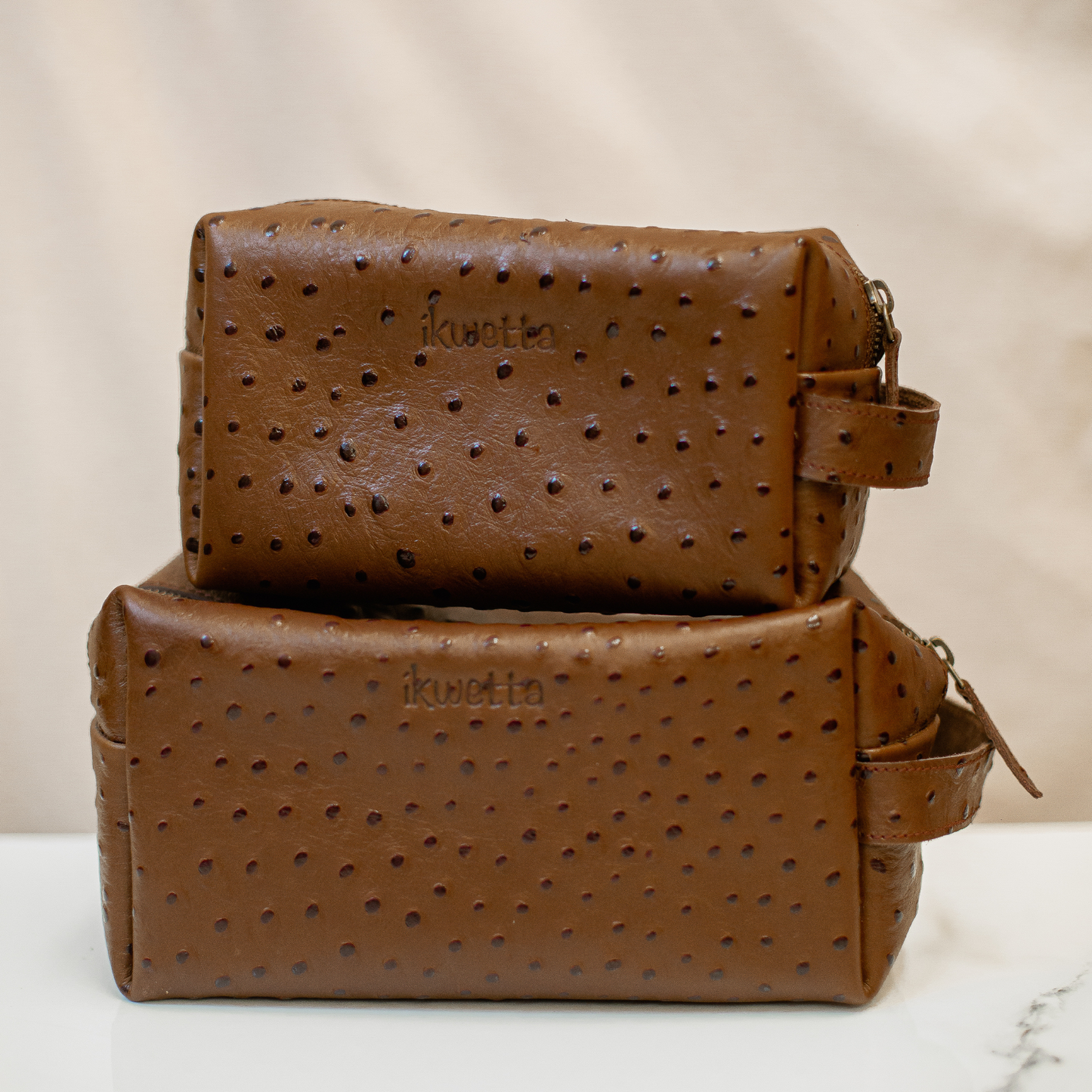 Travel case in brown ostrich print leather