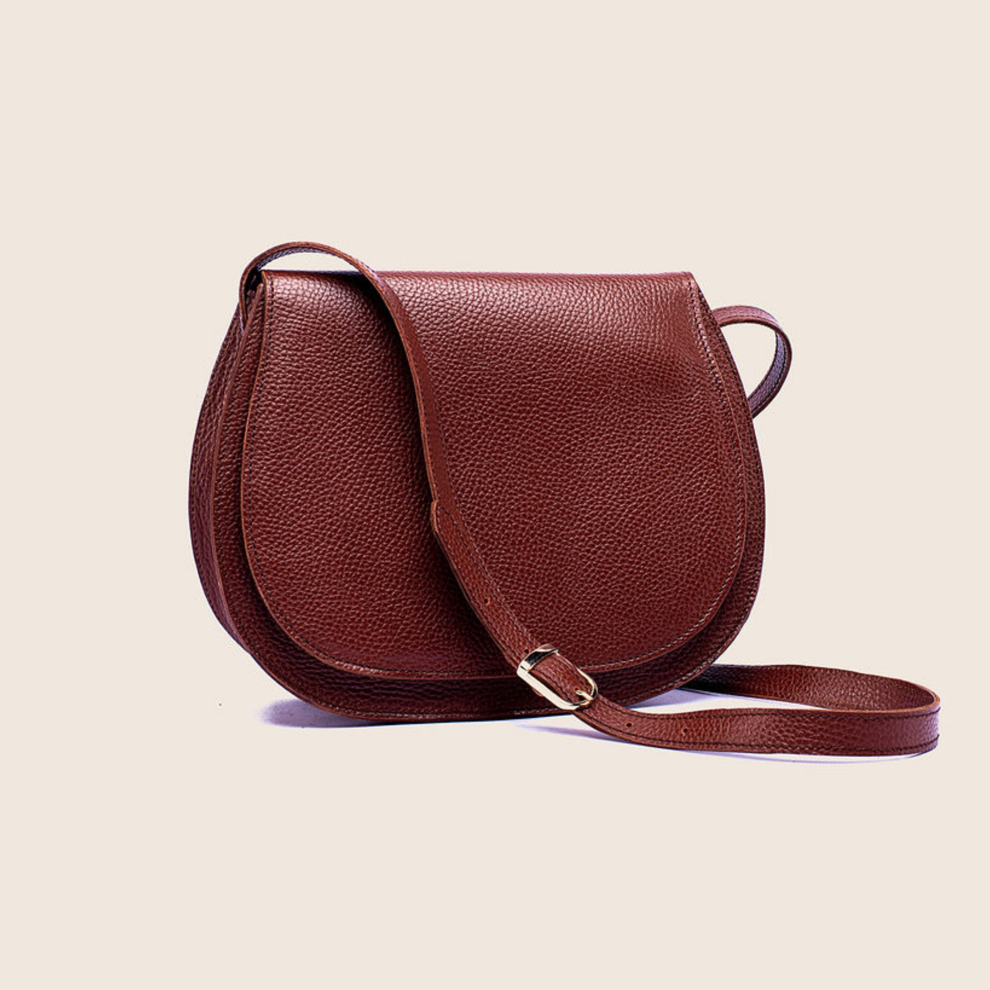 Saddle crossbody in Firebrick milled leather with a crossbody strap