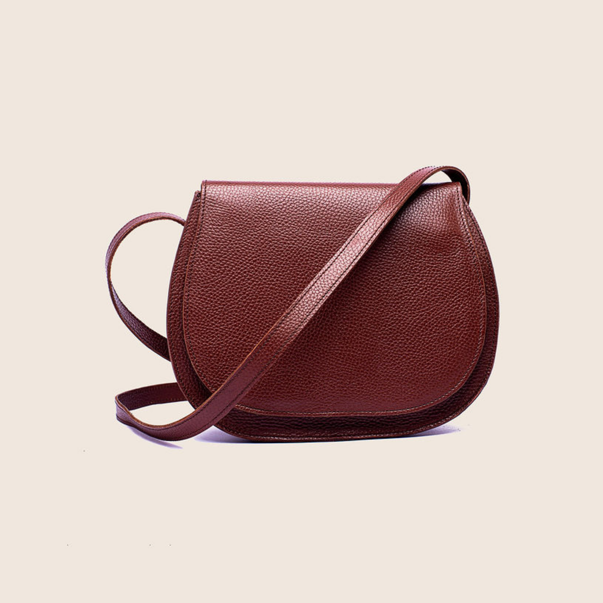 Saddle crossbody in Firebrick milled leather with a crossbody strap